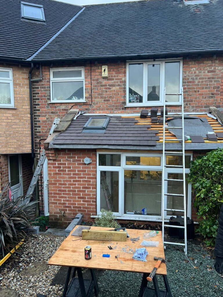 This is a photo of a roof extension that is having new roof tiles installed. This is a photo taken from the roof ridge looking down a tiled pitched roof on to a flat roof. Works carried out by Hedge End Roofing Repairs