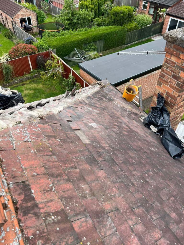 This is a photo taken from a roof which is being repaired. It shows a street of houses, and their roofs