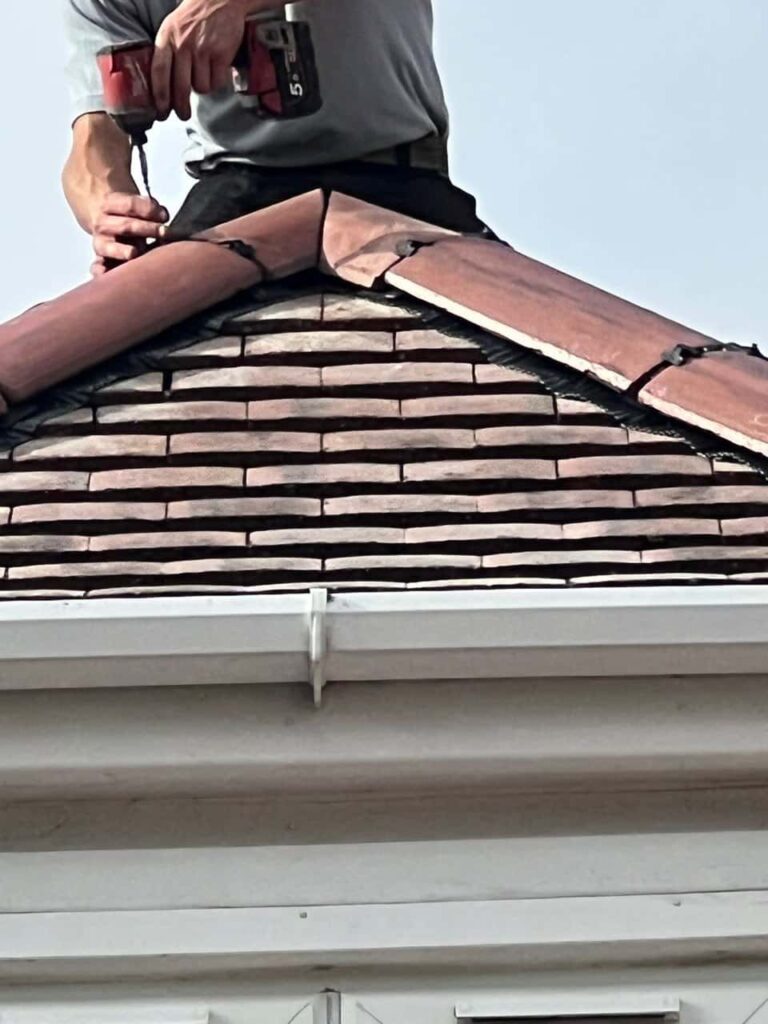 This is a photo of one of the operatives of Hedge End Roofing Repairs installing new ridge tiles